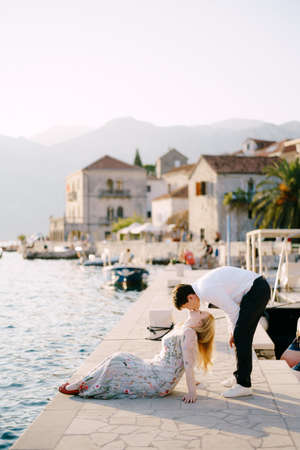 Man kisses woman sitting on the banks of Perastの写真素材