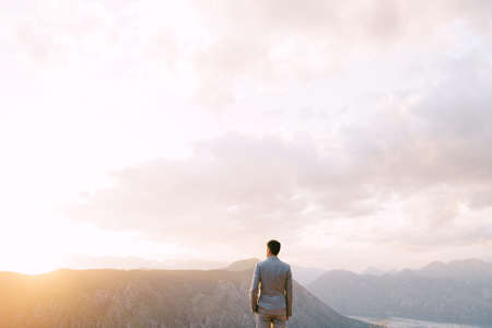Man stands on the top of a mountain. Back viewの写真素材