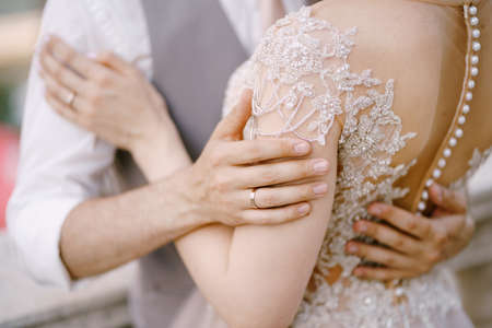 Embrace of groom and bride in a lace dress. Close-upの写真素材