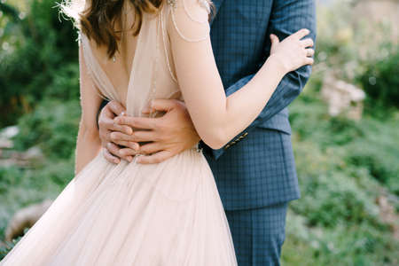 Groom hugs bride waist. Close-upの写真素材