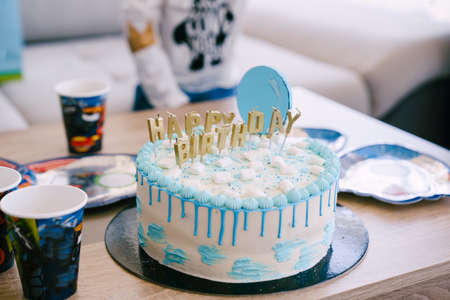 Festive blue and white birthday cake is on the tableの写真素材