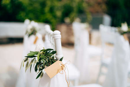 White wooden chair decorated with green branches and paper tagsの写真素材