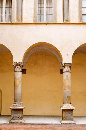 Antique columns near the arched corridor outside the buildingの写真素材