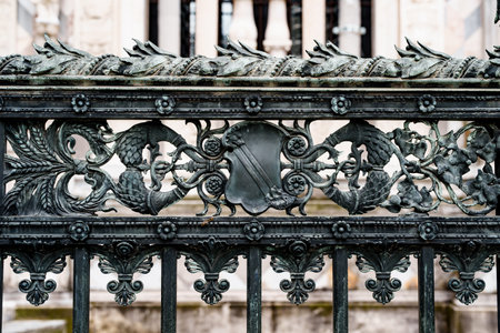 Antique wrought iron fence near the Duomo Cathedral in Milan with spikelets, shields, flowers and curlsの写真素材