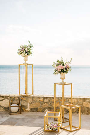 Wedding bouquets of flowers in vases stand on the observation deck against the background of the seaの写真素材