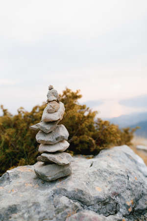Pyramid of stones on a large stone at the top of a mountainの写真素材