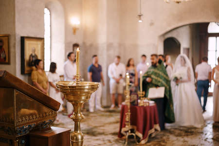 Lighted candles on stands in the church during the wedding ceremonyの写真素材