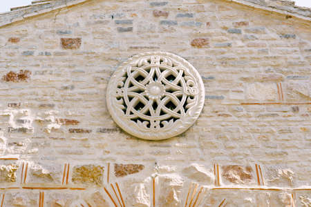 Rose window with ornaments and patterns on the stone wall of the churchの写真素材