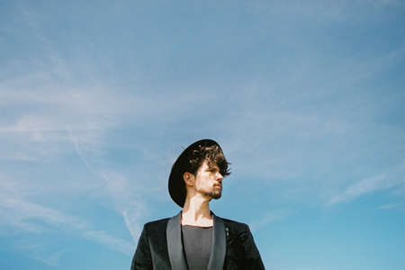 Portrait of a man in a black hat against a turquoise skyの写真素材