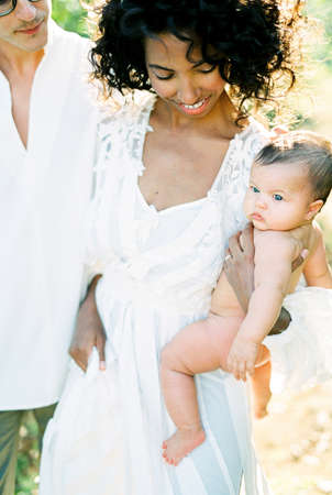 Man hug a woman with a newborn in her arms