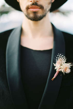 Boutonniere is pinned to the groom jacket. Close-up