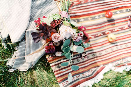 Wedding bouquet lies on a homespun bedspreadの写真素材