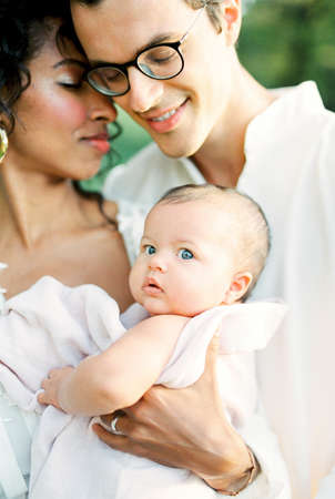 Man hugs a woman with a baby. Portrait