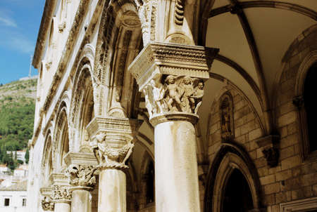 Carved columns under the arched passage of the temple with figures and patternsの写真素材