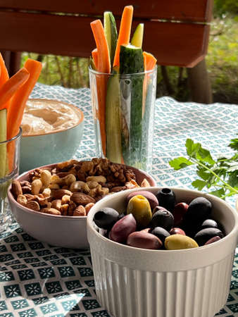 Olives, nuts and vegetables stand on a laid tableの写真素材