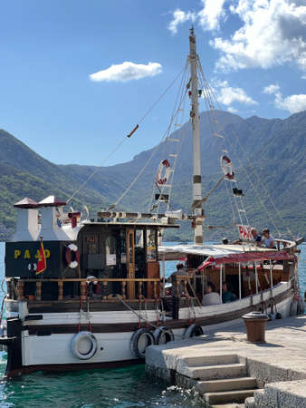 Small sailboat at the pier against the backdrop of mountains