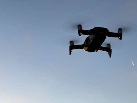 Drone hovering in the air against the blue skyの写真素材