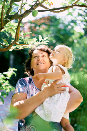 Woman holding a little girl in her arms and looking up