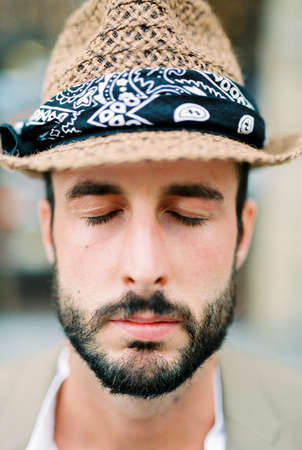 Man in a beige hat with his eyes closed. Portraitの写真素材