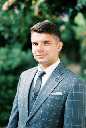 Man in a gray checkered suit in the garden. Portraitの写真素材