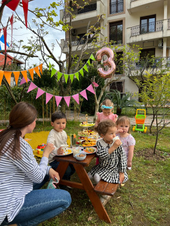 Budva, Montenegro - 01.08.22: Woman is sitting next to the children at the table and celebrating a birthdayのeditorial素材