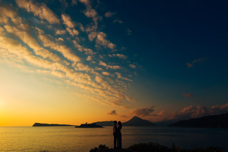 Tivat, Montenegro - 18 april 2021: Woman with man embracing posing against the backdrop of mountains at sunsetのeditorial素材