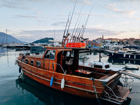 Budva, Montenegro - 12.07.22: Wooden fishing boat stands at the pier at sunsetのeditorial素材