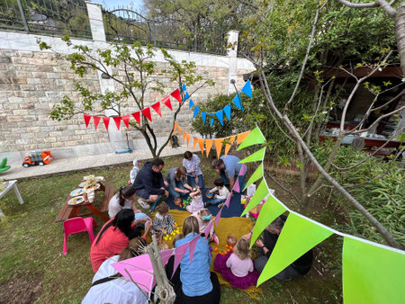 Budva, Montenegro - 12.07.22: Children with parents celebrate birthday on bedspreads in the gardenのeditorial素材