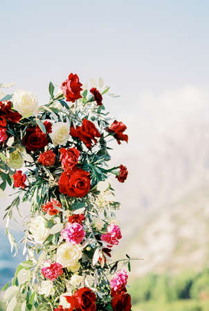 Fragment of a wedding arch with white and red roses and carnations. Close-upの写真素材