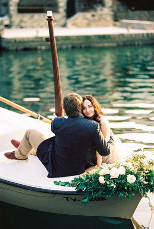 Man and woman hugging in a boat decorated with flowersの写真素材