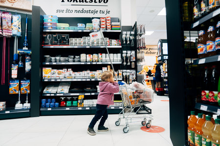 Budva, Montenegro - 17 march 2021: A child with a small cart in a supermarket.のeditorial素材