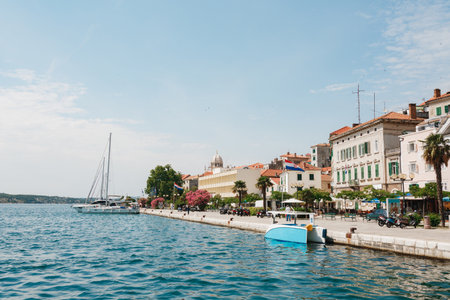 Sibenik, Croatia - 12.07.2019: Yacht and boat stand near the embankment of Sibenik on the background of ancient buildings and a beautiful blue skyのeditorial素材