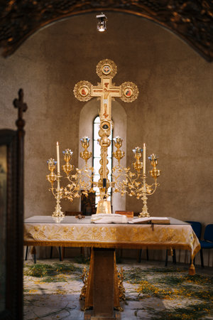 Tivat, Montenegro - 02.07.21: Branched gold candlestick on a table in front of a cross in the Church of St. Sava in Tivatのeditorial素材