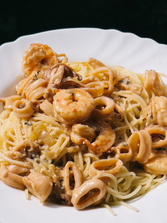 Shrimps in sauce lie on pasta in a plateの写真素材