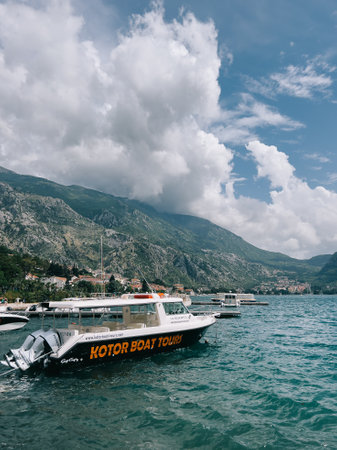 Tourist boat is moored near the shore. Caption: Kotor boat tours