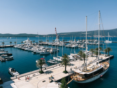 Sailing yacht moored at a tiled pier with potted palm treesの写真素材