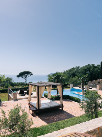 Double sun lounger with a canopy and curtains stands by the poolの写真素材