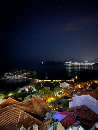 View of the ancient houses with illumination and the island of Sveti Stefan at night