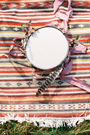 Tambourine lies on a motley homespun bedspread. Top viewの写真素材