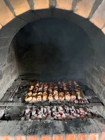 Juicy kebabs are cooked on skewers in a brick ovenの写真素材