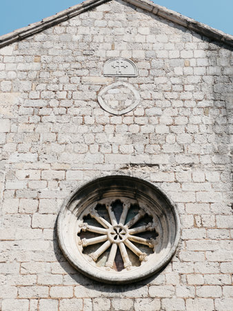 Rose window on the stone wall of an old churchの写真素材