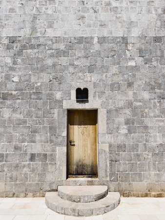 Wooden door on the stone facade of the Church of the Holy Trinity. Budva, Montenegroの写真素材