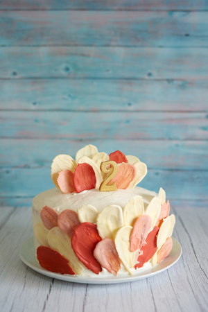 Birthday biscuit cake stands on a light wooden table. Caption: 2の写真素材