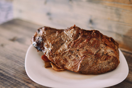 Juicy fried tenderloin with spices and vegetables lies on a plateの写真素材