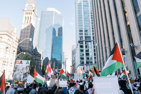 Toronto, Canada - 28 October 2023: Anti-war march in Toronto by Palestinians against Israels aggression in Gaza. Citys peaceful protest against Israel-HAMAS war. Protesters wave flagsのeditorial素材
