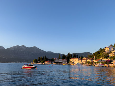 Motor yacht in the sea near the ancient resort town at the foot of the mountainsの写真素材