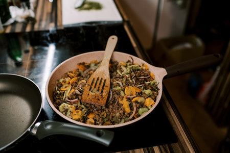 Minced meat with pieces of vegetables is stewed in a pan on the stoveの写真素材