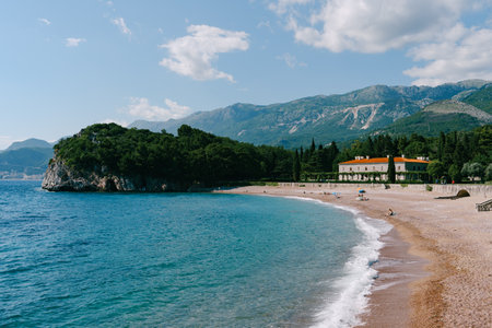 Waves roll on the sandy beach near Villa Milocer in a green garden at the foot of the mountains. Montenegroの写真素材