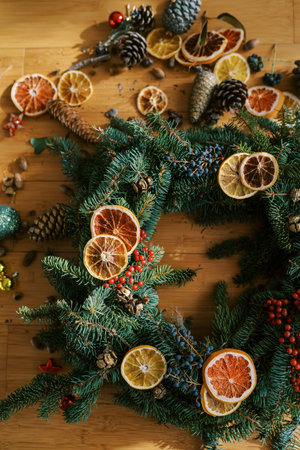 Christmas wreath of pieces of dried fruits and berries lies on the floor. Top view. Croppedの写真素材