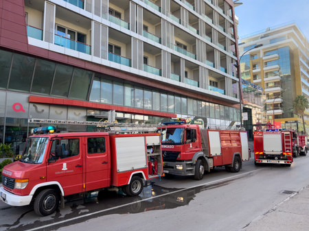 Budva, Montenegro - 09 august 2023: Red fire trucks stand in a row near a multi-storey building on...